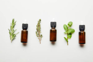 Essential-Oils-300x200 Flat lay with herbs and bottles with essential oil on white background